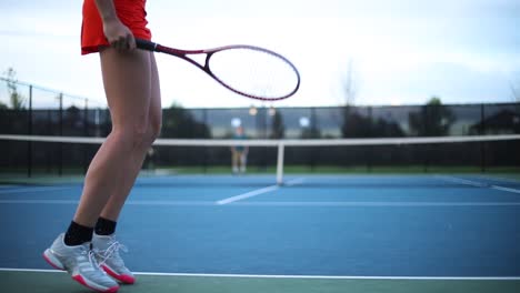 Woman-warming-up-preparing-to-serve-a-shot-in-a-tennis-match