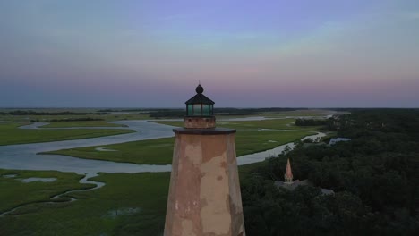 Circling-around-Old-Baldy-Lighthouse-revealing-an-amazing-sunset-I-Bald-Head-Island,-North-Carolina