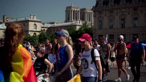 Eine-Kleine-Gruppe-Von-Menschen-Bei-Der-Pride-Parade,-Die-Nach-Dem-Brand-Auf-Der-Brücke-Bei-Chatlet-Mit-Der-Notre-Dame-Kirche-Im-Hintergrund-Marschierte