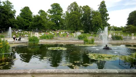 Jardines-De-Kensington-En-Flor-Y-Mostrando-Estanques-Y-Fuentes,-Junto-Con-Visitantes-En-Un-Día-Soleado,-Londres,-Reino-Unido