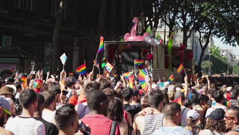 Gay-Pride-Marschteilnehmer-Schwenken-Die-Regenbogenfahnen-Und-Amüsieren-Sich-Hinter-Einem-Truck,-Der-Musik-Für-Sie-Spielt