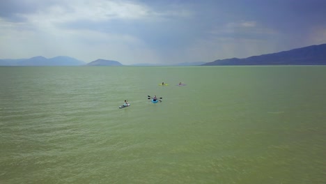 Drone-shot-flying-over-a-small-group-of-people-kayaking-at-Utah-Lake