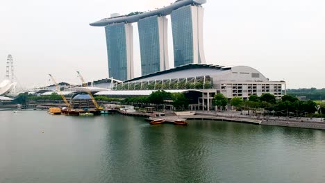 Low-flying-aerial-establishing-shot-of-Marina-Bay-Sands-Hotel-and-Art-Science-Museum,-Singapore