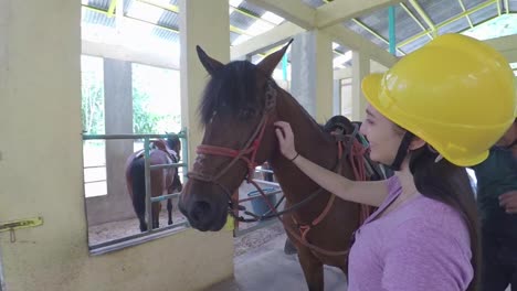 Girl-Smiles-While-She-Pets-Horse-With-Instructor