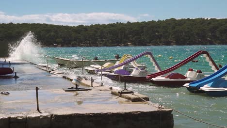 Botes-De-Pedal-Balanceándose-En-Olas-En-Un-Muelle-Con-Agua-Salpicada-En-Cámara-Lenta