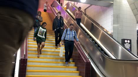 Communters-arrive-on-the-platform-at-Central-Station-down-the-stairs-and-escallators-at-rush-hour,-Brisbane-Australia