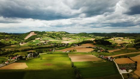 Luftaufnahme-Der-Slowenischen-Landschaft-Mit-Hügeln,-Häusern-Und-Landwirtschaftlichen-Feldern,-Bewölktem-Himmel,-Slowenien,-Europa