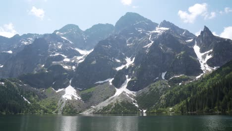 Still-shot-of-the-Tatra-mountains-with-snow-on-summer-and-the-lake-of-Morskie-Oko