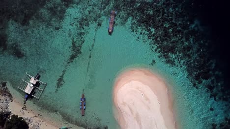 Aerial-above-beautiful-white-sandy-beach,-clear-turquoise-water,-boat-and-pontoon