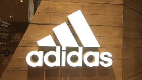 Logotipo-De-La-Marca-Adidas,-Tienda-Deportiva-En-El-Centro-Comercial,-Acercamiento-Suave,-Editorial