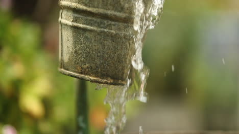 Wasser-Fällt-In-Zeitlupe-In-Einem-Garten-Aus-Einem-DIY-Außenhahn,-Der-Einen-Rustikalen-Eimer-überläuft