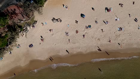Aerial-top-down-view-of-swimmers-on-the-beach-at-Noosa-Main-Beach,-Noosa-Heads,-Queensland,-Australia