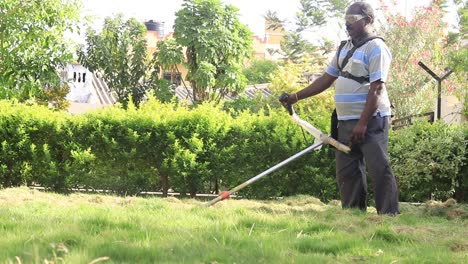 Man-uses-motorized-petrol-fueled-grass-mower-to-trim-lawn-with-no-protective-suit