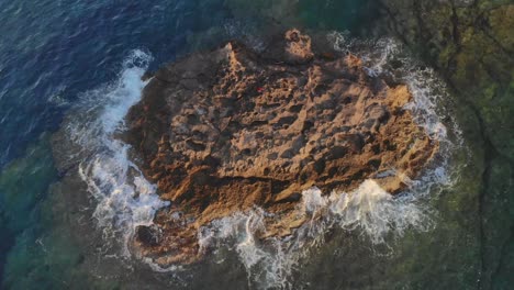 Waves-hitting-rocks-against-tiny-island-in-ocean