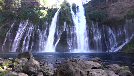 4K-footage-of-Burney-Falls,-with-a-steady-wide-angle-shot-centered-in-the-middle-of-the-cascading-waterfall-and-rocks-to-show-depth-of-field