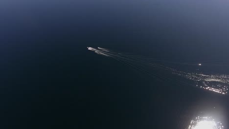 Aerial-view-of-two-waterskiers-behind-a-motorboat
