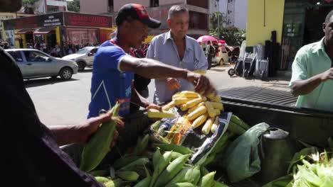 Man-prepares-corn-to-be-sold-at-the-morning-market,-in-Capelinha,-Minas-Gerais,-Brazil