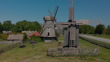 An-aerial-shot-backwards-from-a-wooden-mill-moving-until-than-other-two-appears-in-the-scene