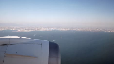 View-from-inside-the-plane-cabin-while-approaching-to-land-at-Tokyo-Airport-see-Japan's-land-and-Japan-Harbour-in-background-in-early-morning-spring-time