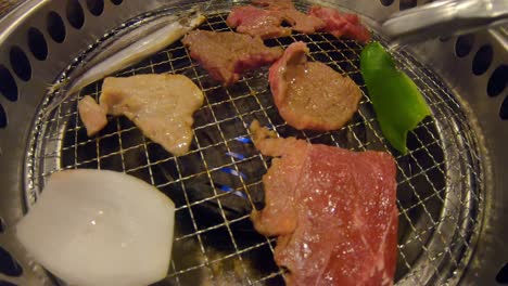 Zange,-Die-Gegrilltes-Fleisch-Auf-Yakiniku-japanischem-Grill-Shichirin-Dreht