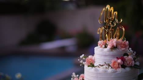 Smooth-shot-of-a-beautifully-decorated-wedding-cake-on-a-fancy-platter-at-a-wedding-reception