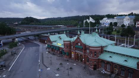Wide-Shot-of-Boras-Central-Station-By-The-Bridge-With-Cars,-Train-Tracks-and-a-Forest-By-The-Horizon