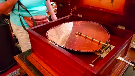 Shot-of-antique-wooden-Polyphon-playing-music-from-copper-disc-in-antique-store-in-the-city-of-Solvang,-California,-USA