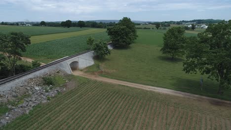 Luftaufnahme-Von-Amish-Ackerland-Auf-Der-Eisenbahnstrecke