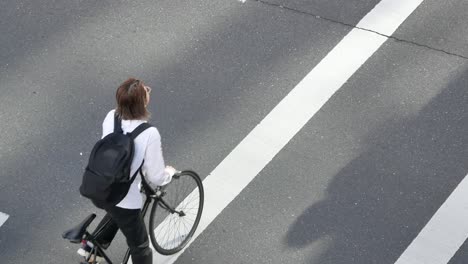 Zooming-in-to-the-foot-of-people-with-view-of-the-street-crossing-way-with-many-people-are-crossing-the-road-in-the-city-center-of-Tokyo,Japan-in-day-time