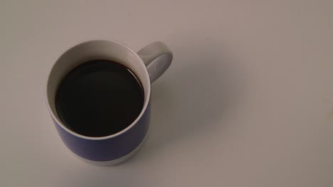 Mano-Caucásica-Vertiendo-Leche-Sin-Lactosa-En-Una-Taza-De-Café-Azul