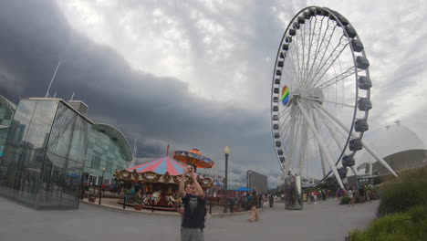 Editorial,-Time-Lapse-view-of-Navy-Pier-Chicago,-ferris-wheel-and-rides,-people-passing-and-extreme-weather,-storm,-thunderstorm-approaching,-strong-clouds-rolling-and-coming-fast-towards-the-rides