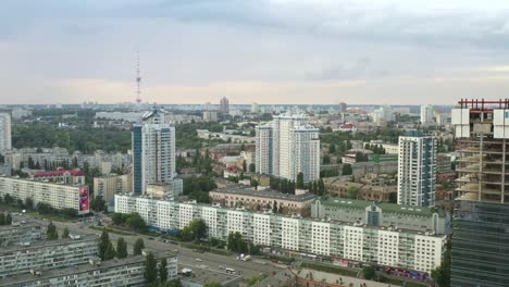 Vista-Aérea-De-Edificios-Por-Calle-Muy-Transitada-Al-Lado-Del-Edificio-En-Construcción-En-Kiev,-Ucrania