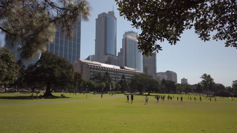 Office-workers-playing-soccer-and-exercise-during-lunch-break-in-a-park