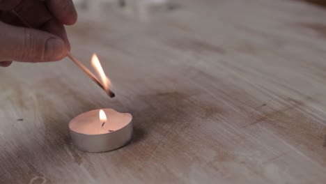 Hand-lighting-candle-with-matches