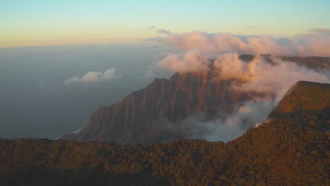 Aerial-view-of-Napali-Coast-at-sunset,-Clouds-on-mountain-range-Hawaii