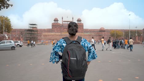 Chica-Con-Mochila-De-Pie-Contra-El-Antiguo-Monumento-Histórico-Fuerte-Rojo-Famoso-Destino-Turístico-En-Nueva-Delhi-India-Asia-Primer-Plano