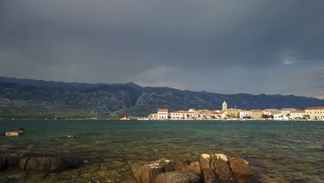 Time-lapse-of-coastal-town-in-Croatia,-mountains-and-cloudscape-in-background,-panoramic-view-of-small-village-and-harbor,-Vinjerac,-Croatia,-Paklenica-National-park-in-Velebit