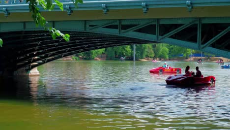 Városligeti-Lake-City-park,-paddling-boats-under-the-bridge,-continue-shot-1