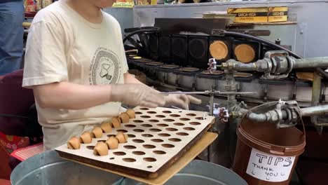 A-lady-making-fortune-cookies-at-the-famous-"Golden-Gate-Fortune-Cookie-Company"-in-San-Francisco's-historic-Chinatown