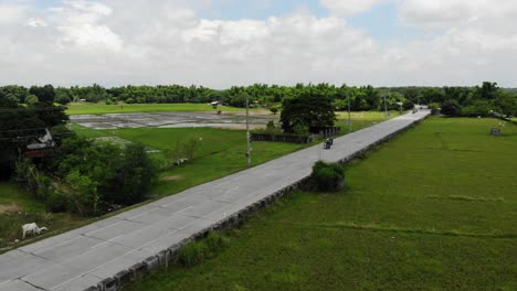 Luftaufnahme-Einer-Zweispurigen-Autobahn-Mit-Minimalem-Verkehr-In-Der-Provinz-Malasiqui,-Pangasinan,-Philippinen,-Umgeben-Von-Riesigen-Landwirtschaftlichen-Feldern