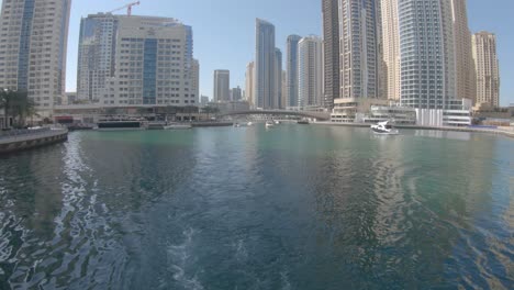 Dubai-Marina,-skyscrapers-view-from-floating-boat,-point-of-view-perspective