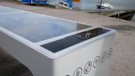 Alternative-renewable-energy-modern-smart-solar-bench-USB-wifi-charging-station-on-waterfront