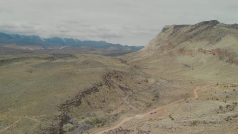 Expansive-aerial-pan-up-of-a-long-dirt-road-out-to-southern-Utah's-Toquerville-Falls