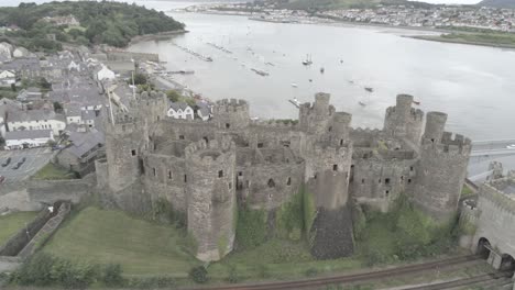 Medieval-landmark-historic-Conwy-castle-aerial-view-above-Welsh-seaside-landscape-pan-right