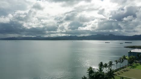 Aerial-forward-over-coastal-area-of-Suva,-largest-city-in-Fiji,-dramatic-clouds