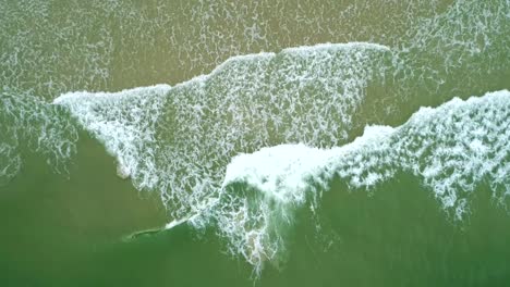 Zenithal-plane-with-Drone-of-waves-breaking-in-the-sea,-beautiful-texture-and-foam-of-the-waves-breaking,-perfect-light