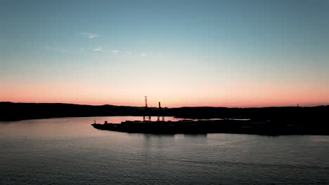 Kräne-Vom-Frachthafen-Larvik-Mit-Einem-Wunderschönen-Blauen-Und-Orangefarbenen-Sonnenuntergang-Im-Hintergrund