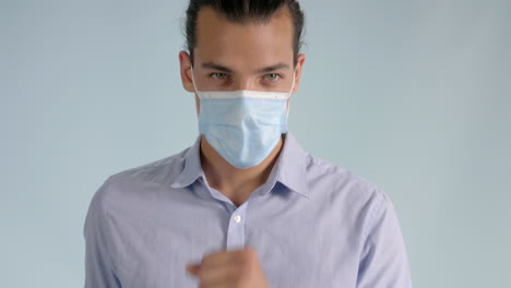 Young-man-wearing-a-protective-medical-face-mask-coughing-from-a-viral-infection