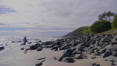 Surfers-walking-on-the-rocky-beach---Crescent-Head-NSW-Australia---Slow-motion