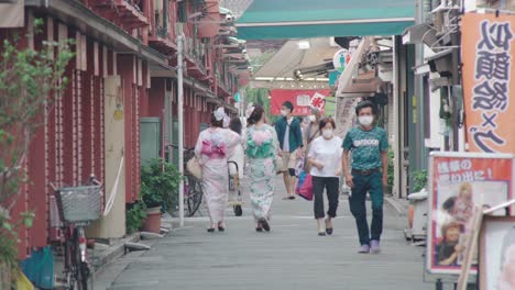 Zwei-Japanische-Mädchen-Im-Kimono-Gehen-Auf-Der-Seitenstraße-In-Der-Nähe-Der-Nakamise-Einkaufsstraße-In-Asakusa,-Tokio,-Japan---Totale